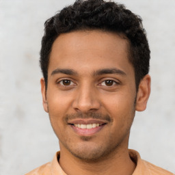 Joyful latino young-adult male with short  black hair and brown eyes