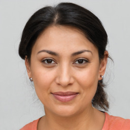 Joyful latino young-adult female with medium  brown hair and brown eyes