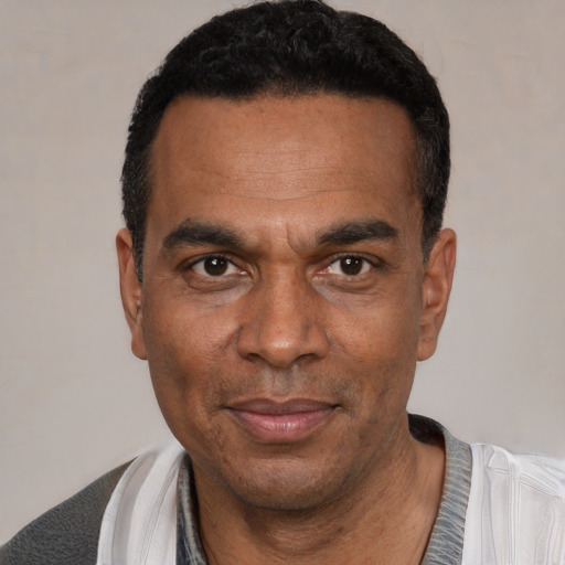 Joyful black adult male with short  black hair and brown eyes