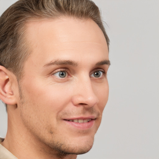 Joyful white young-adult male with short  brown hair and grey eyes