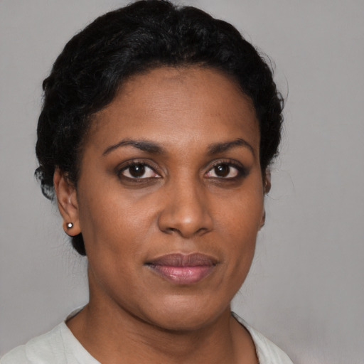 Joyful black young-adult female with short  black hair and brown eyes