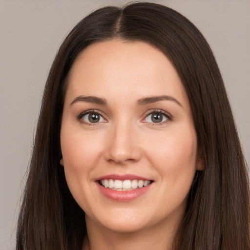 Joyful white young-adult female with long  brown hair and brown eyes