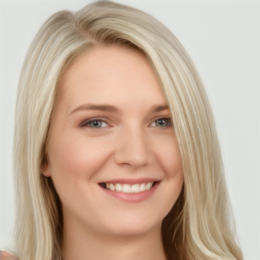 Joyful white young-adult female with long  blond hair and brown eyes