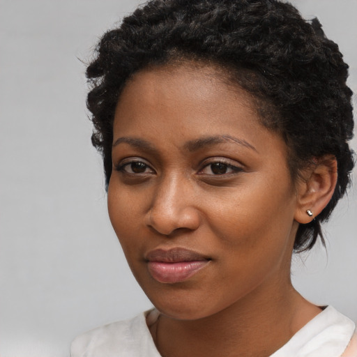 Joyful black young-adult female with short  brown hair and brown eyes