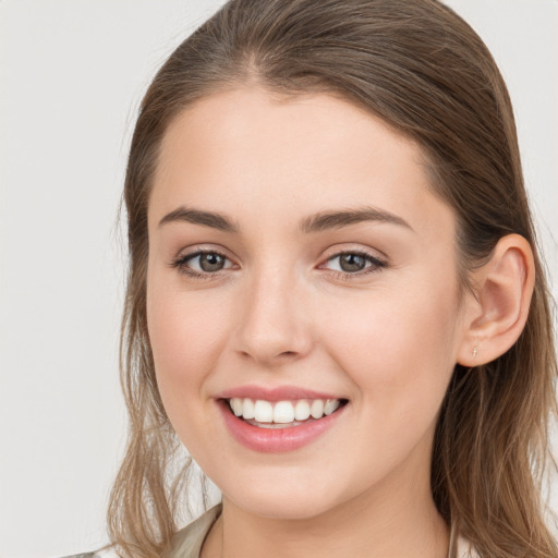 Joyful white young-adult female with long  brown hair and grey eyes