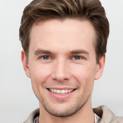 Joyful white young-adult male with short  brown hair and grey eyes