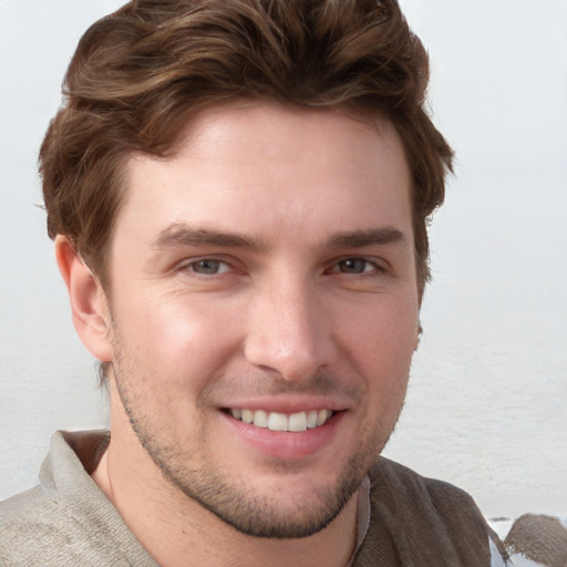 Joyful white young-adult male with short  brown hair and blue eyes