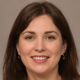 Joyful white adult female with long  brown hair and grey eyes