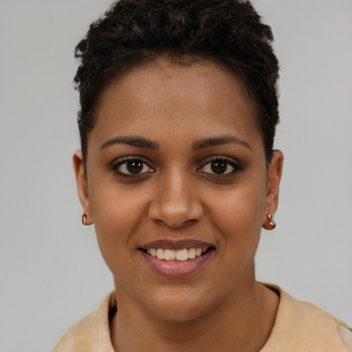 Joyful black young-adult female with short  brown hair and brown eyes