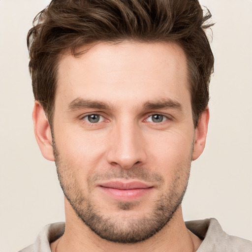 Joyful white young-adult male with short  brown hair and grey eyes