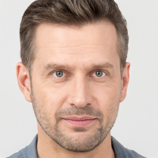 Joyful white adult male with short  brown hair and grey eyes