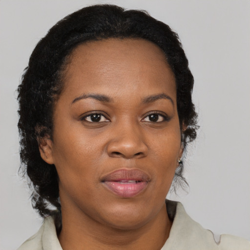 Joyful black adult female with medium  brown hair and brown eyes