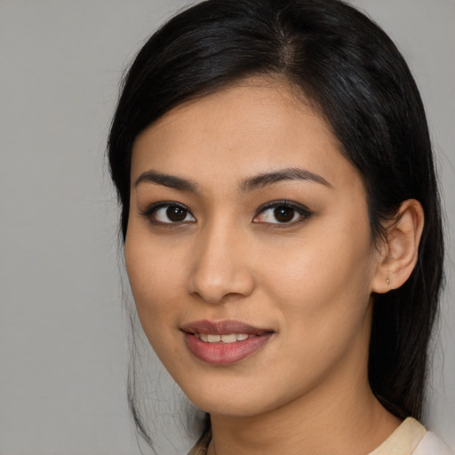 Joyful latino young-adult female with medium  brown hair and brown eyes