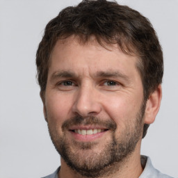 Joyful white adult male with short  brown hair and brown eyes