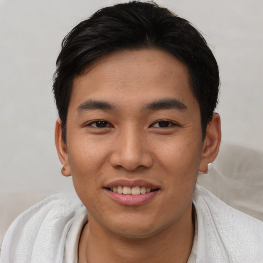Joyful asian young-adult male with short  black hair and brown eyes