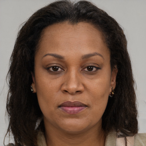 Joyful black adult female with long  brown hair and brown eyes