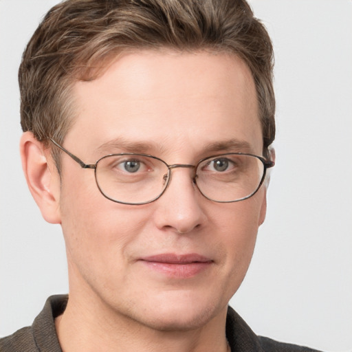 Joyful white adult male with short  brown hair and blue eyes