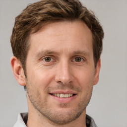 Joyful white adult male with short  brown hair and grey eyes