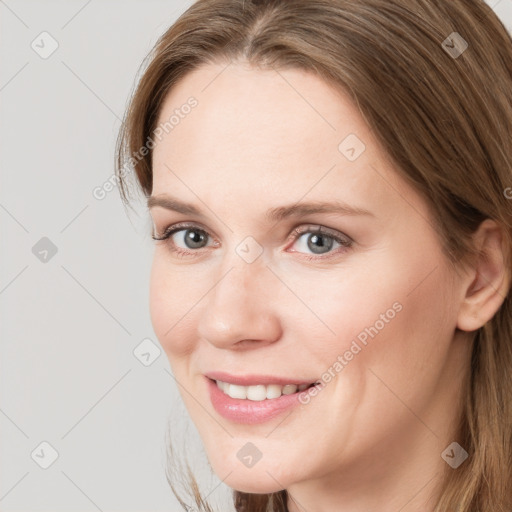 Joyful white young-adult female with long  brown hair and grey eyes