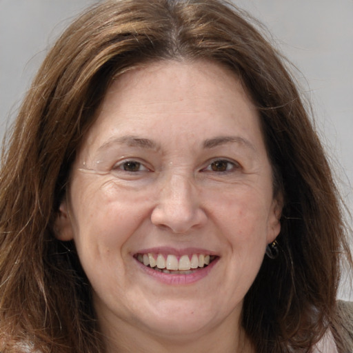 Joyful white adult female with long  brown hair and brown eyes