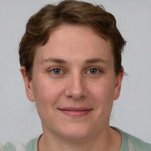 Joyful white young-adult female with short  brown hair and grey eyes