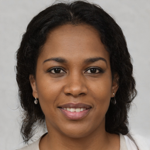 Joyful black young-adult female with medium  brown hair and brown eyes