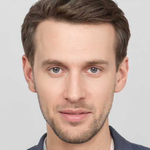 Joyful white young-adult male with short  brown hair and grey eyes