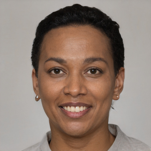 Joyful latino young-adult female with short  black hair and brown eyes