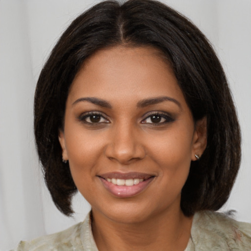 Joyful black young-adult female with medium  brown hair and brown eyes