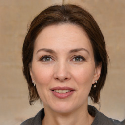 Joyful white adult female with medium  brown hair and grey eyes