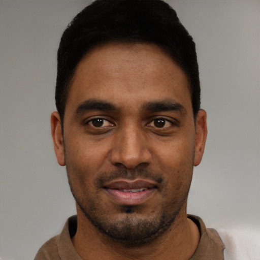 Joyful black young-adult male with short  black hair and brown eyes