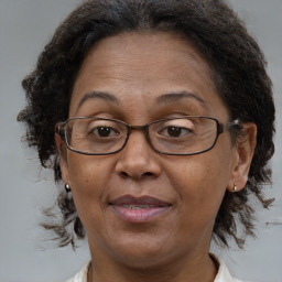 Joyful black adult female with medium  brown hair and brown eyes