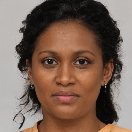 Joyful black young-adult female with medium  brown hair and brown eyes