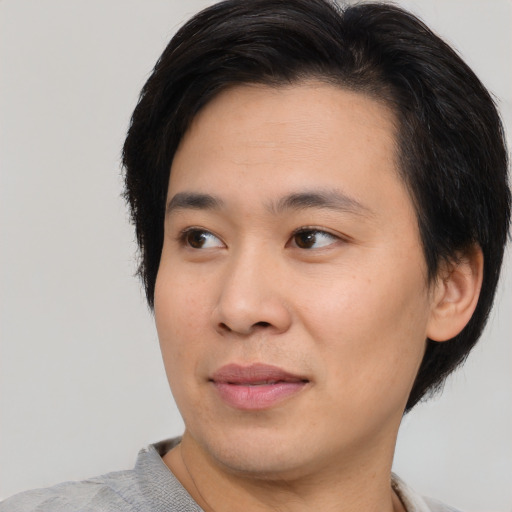 Joyful asian young-adult male with short  black hair and brown eyes