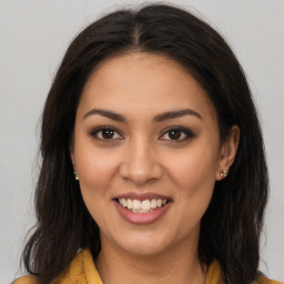 Joyful latino young-adult female with long  brown hair and brown eyes