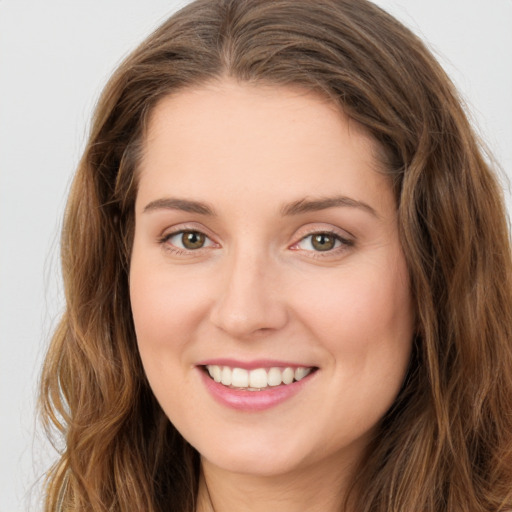 Joyful white young-adult female with long  brown hair and green eyes