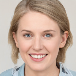 Joyful white young-adult female with medium  brown hair and blue eyes