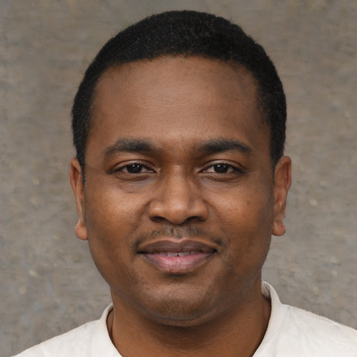 Joyful black young-adult male with short  black hair and brown eyes