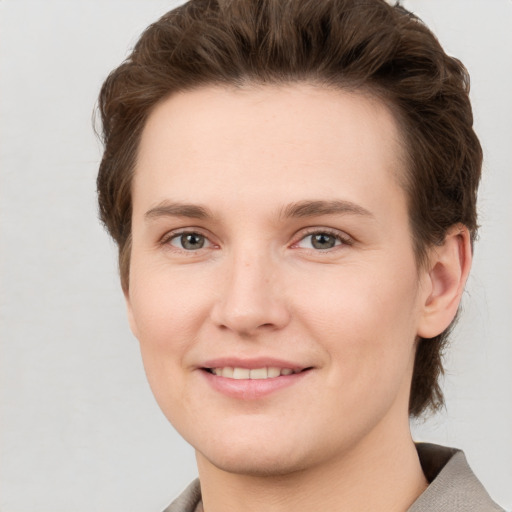 Joyful white young-adult female with short  brown hair and grey eyes