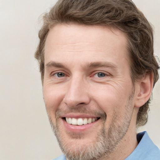 Joyful white adult male with short  brown hair and grey eyes