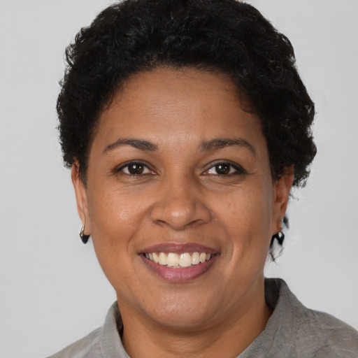 Joyful black adult female with short  brown hair and brown eyes
