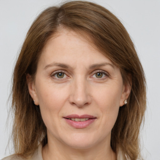 Joyful white adult female with medium  brown hair and green eyes