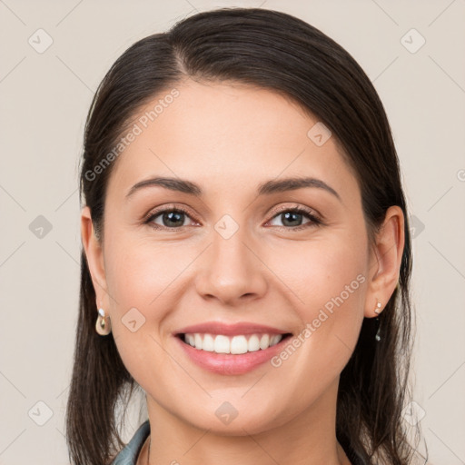 Joyful white young-adult female with long  brown hair and brown eyes