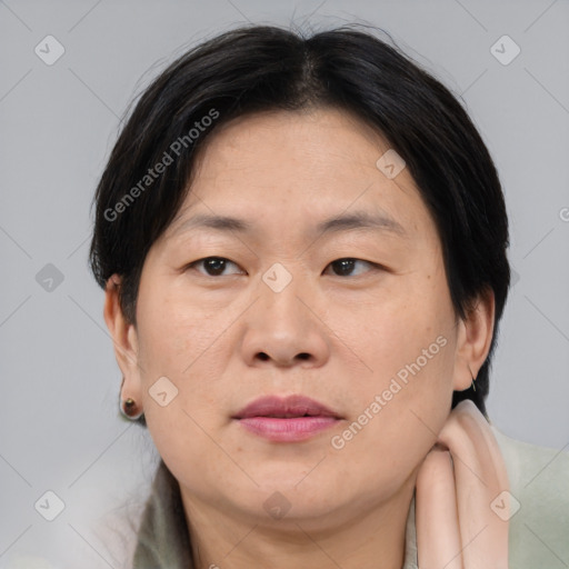 Joyful asian adult female with medium  brown hair and brown eyes