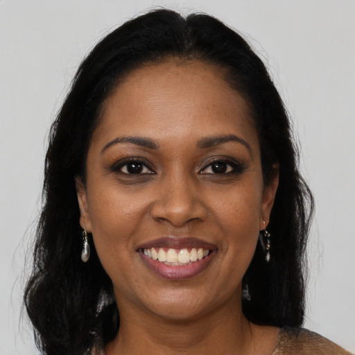 Joyful black young-adult female with long  brown hair and brown eyes