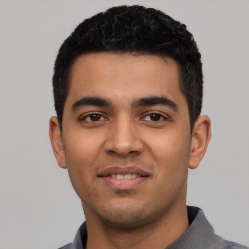 Joyful latino young-adult male with short  black hair and brown eyes