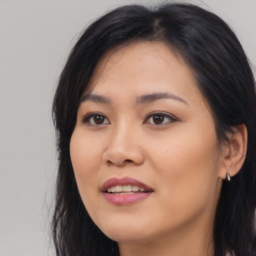 Joyful asian young-adult female with long  black hair and brown eyes