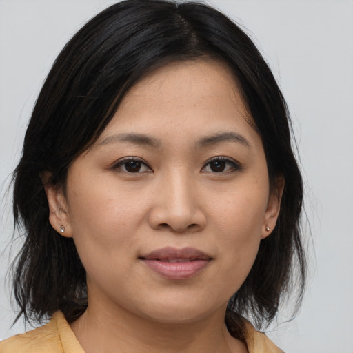 Joyful asian young-adult female with medium  brown hair and brown eyes