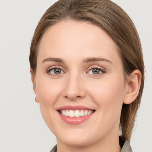 Joyful white young-adult female with long  brown hair and grey eyes