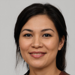 Joyful latino adult female with medium  brown hair and brown eyes